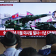 Commuters watch a news program on the TV at Seoul Railway Station in Seoul on May 4, 2019.